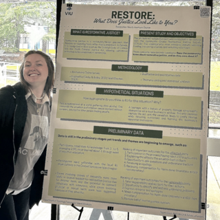 Madelyn in the cafeteria with her research poster