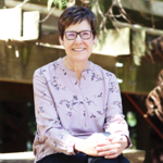 Smiling woman sitting in a garden. 