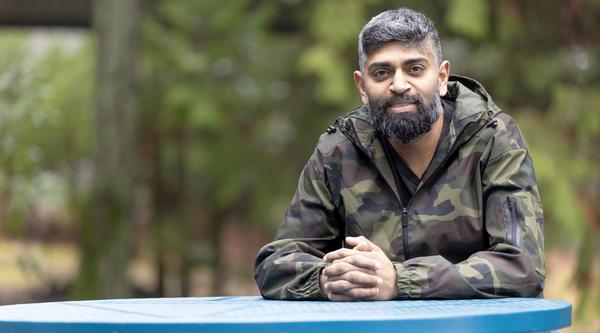 Harold Chandra sits at a blue table outside