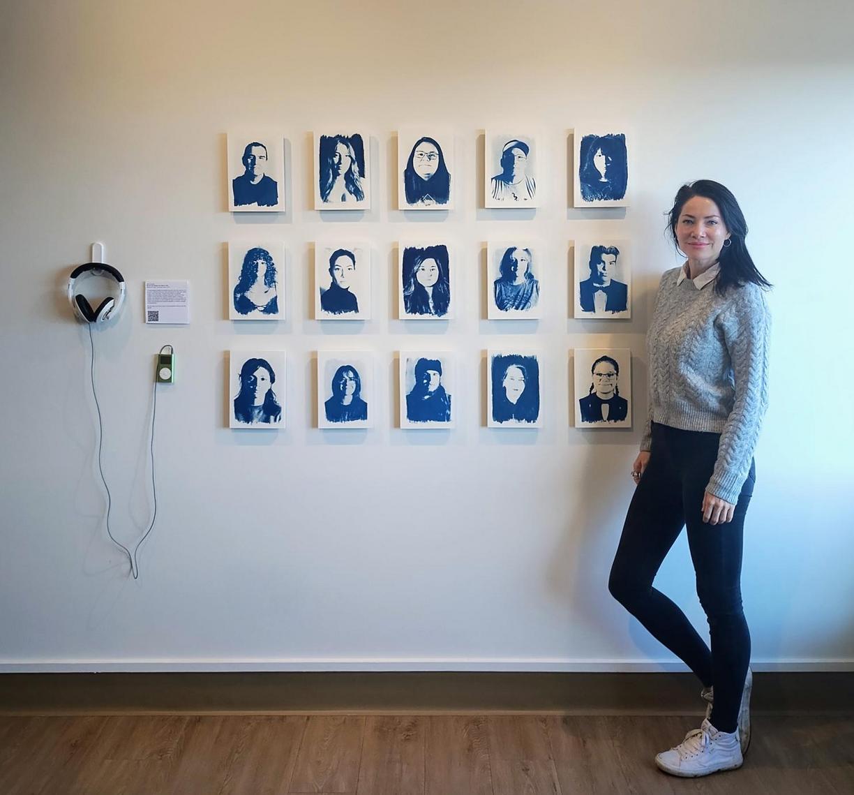 Tarah stands in front of her exhibit