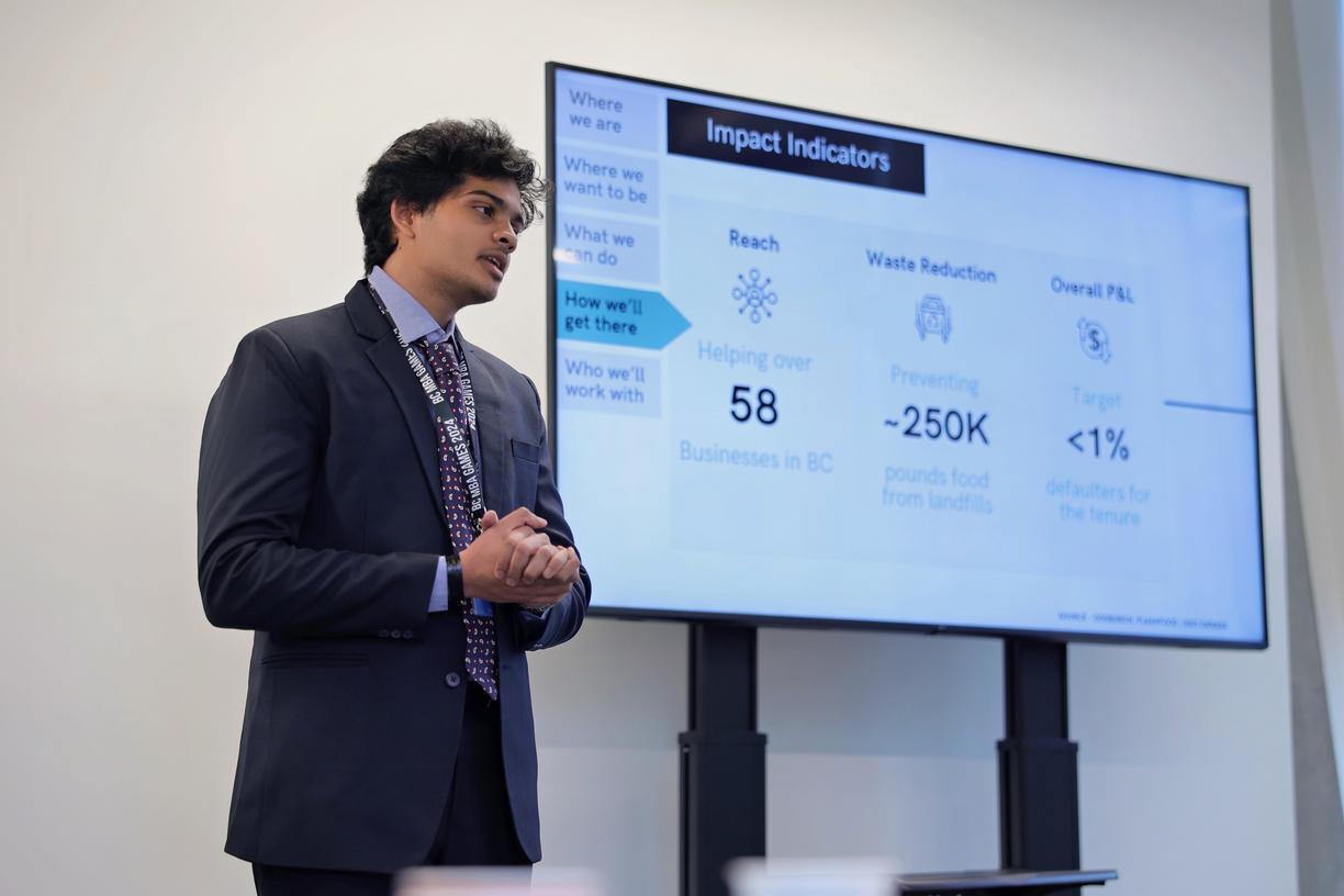 Tejas giving a presentation next to a powerpoint slide.