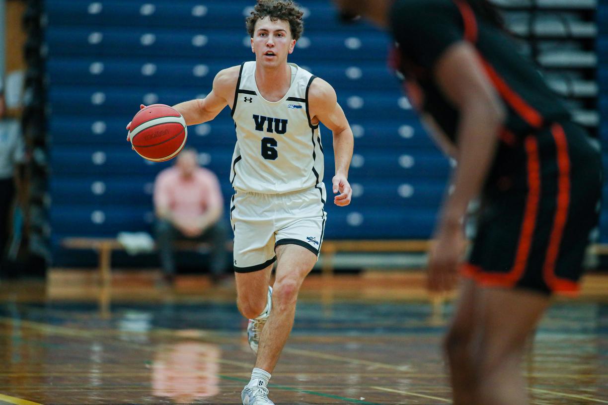 A basketball player runs while dribbling the ball