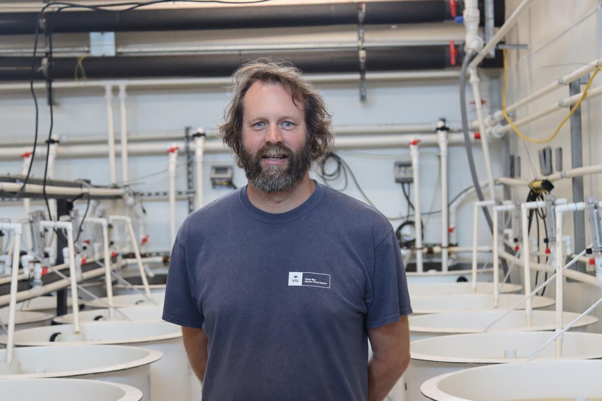 Tim Green standing in the tank room and looking at the camera at VIU Deep Bay Station