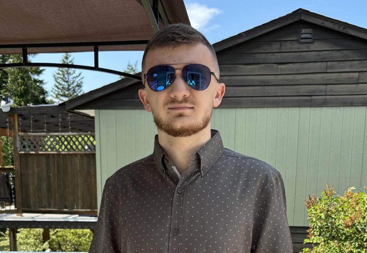 Zackary Sutton outside wearng sunglasses and looking at the camera