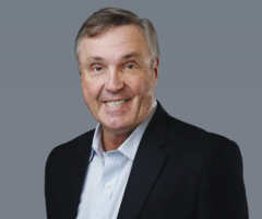 Peter Behie wearing a suit with a grey background