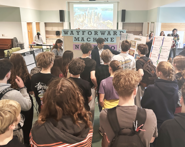 Michael MacKenzie showing a group of students some of the work done for the Futures Fair.