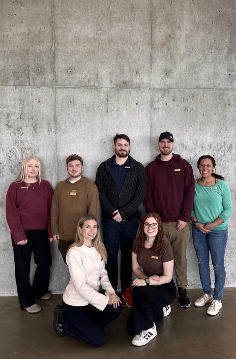 A group of people in front of a concrete wall