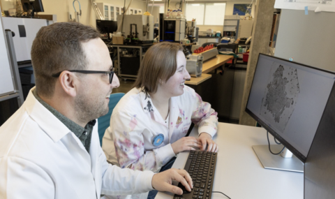 Professor Kyle Duncan and Emily Mahony sitting and looking at a computer screen together.